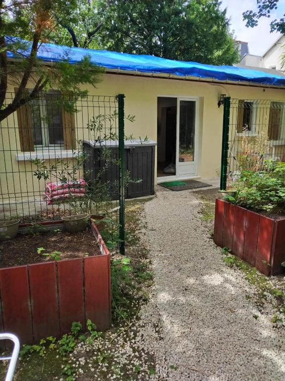 una pequeña casa con techo azul en Charmante petite maison à 15 min de Paris, en Villemomble