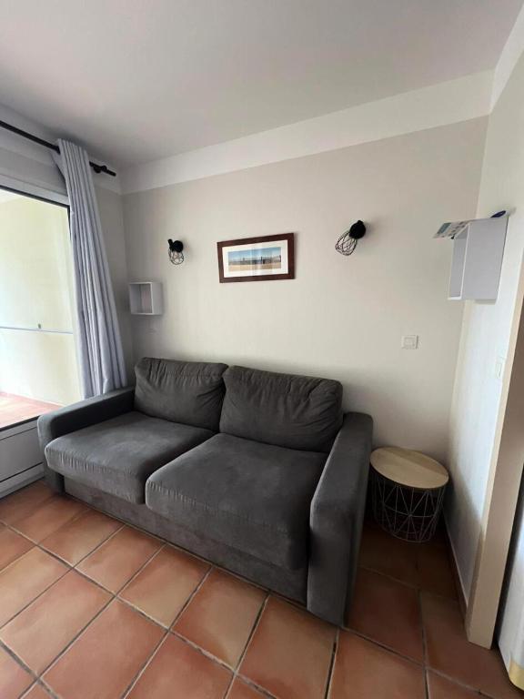 un canapé dans un salon avec une fenêtre dans l'établissement Le Domaine du Golf de Pinsolle - maeva Home - Appartement 2 pièces 4 personnes - Prestige MAE-6651, à Soustons