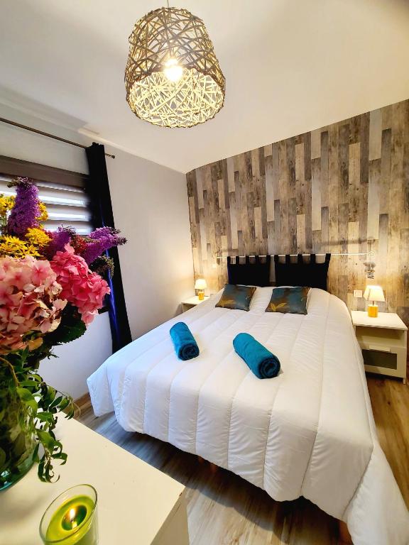 une chambre avec un grand lit blanc avec des oreillers bleus dans l'établissement La Cabane d'Aselia - petite Maison de Pêcheur, à Le Portel