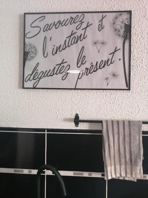 un panneau suspendu sur un mur au-dessus d'un évier dans l'établissement Studio 6 places, à Bagnères-de-Bigorre