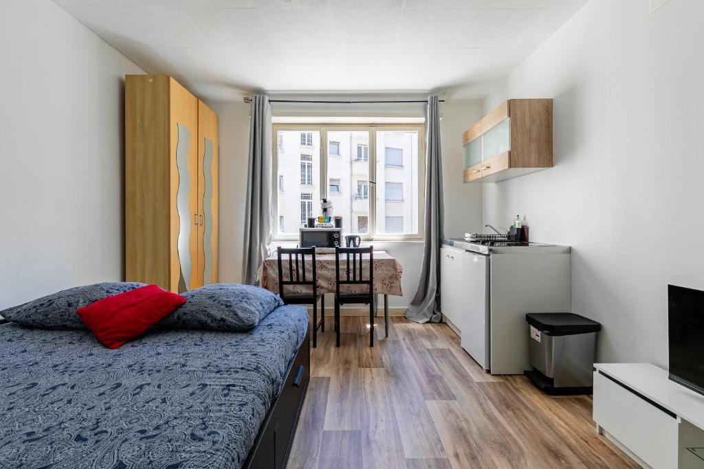 une chambre avec un lit et une cuisine avec une table dans l'établissement Studio Centre / Quartier krutneau, à Strasbourg