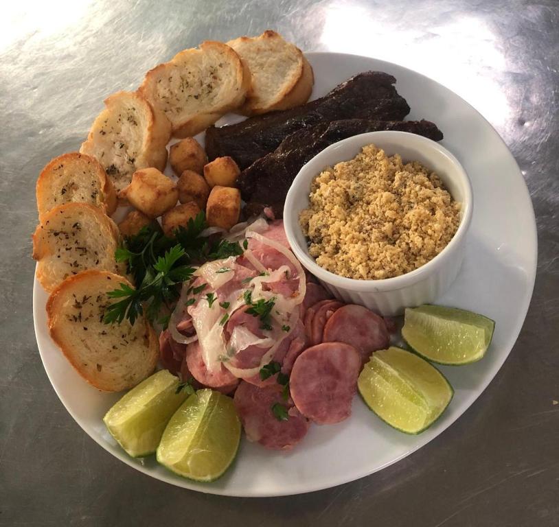 a plate of food with meat and bread and a bowl of dips at Desirée Aeroporto Congonhas 2 in Sao Paulo
