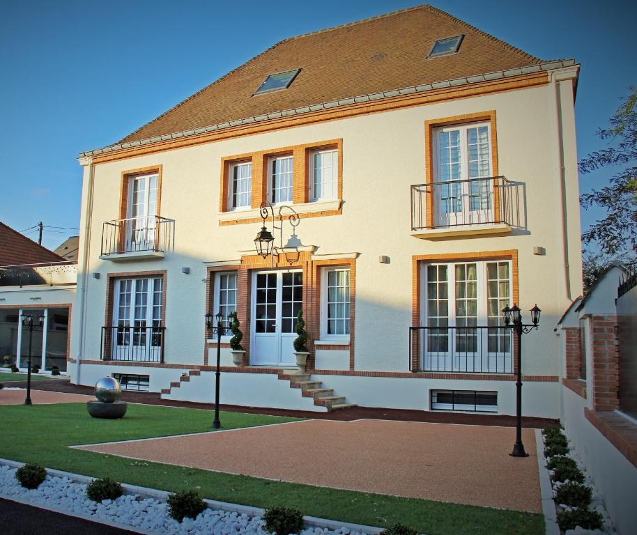 uma grande casa branca com janelas e um telhado em Villa Louis Victor em Dizy