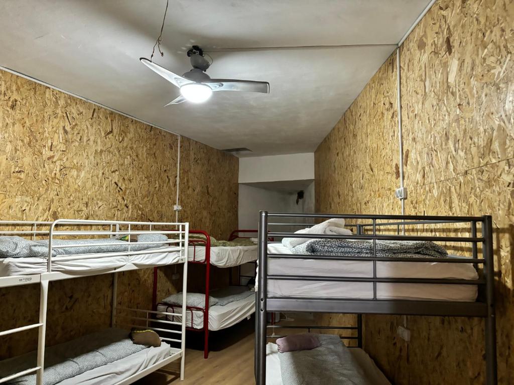 a room with three bunk beds and a ceiling at Backpackers La Gaditana in Alhaurín el Grande