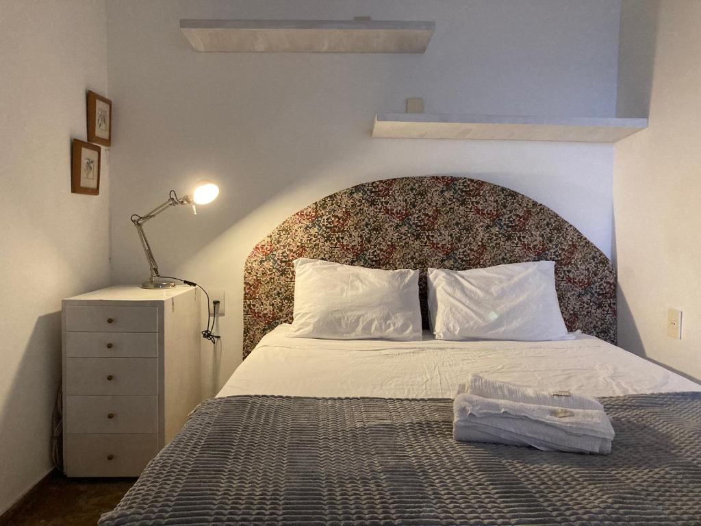 a bedroom with a bed with a large headboard at Chez Zany Boutique Hostel - Copacabana in Rio de Janeiro