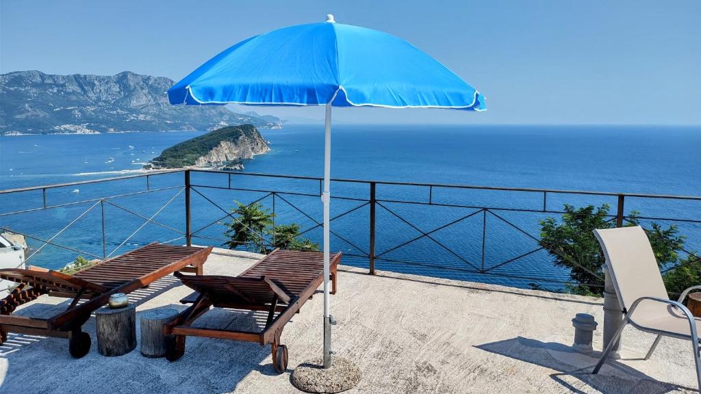 a patio with a table and an umbrella at The High Hostel in Budva