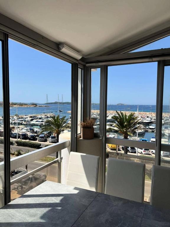 un balcon avec une table et des chaises et une vue sur un port dans l'établissement Résidence Port Helena Coudouliere - Magnifique appartement pour 4 personnes refait a neuf en duplex vue mer MAE-7151, à Six-Fours-les-Plages