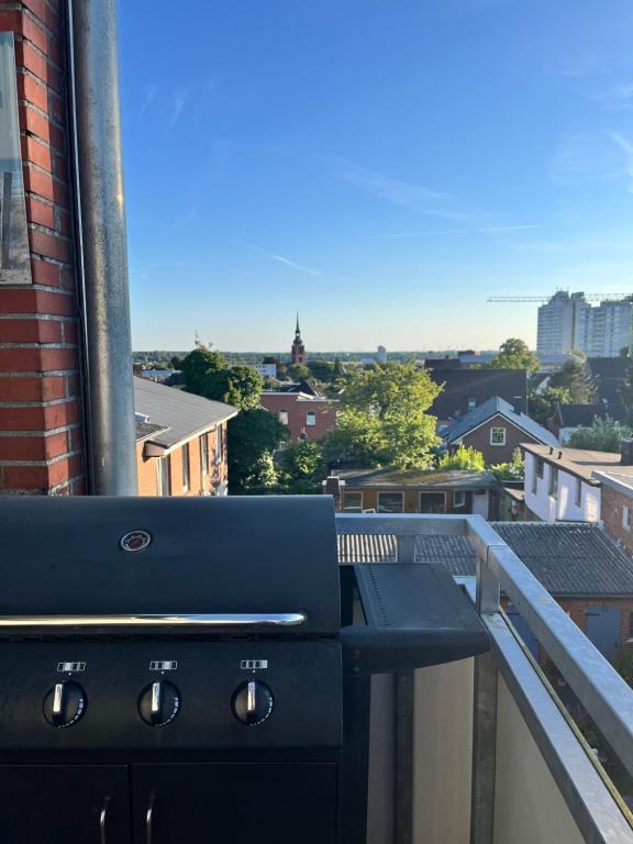 a grill on a balcony with a view of a city at Weitblick in Itzehoe