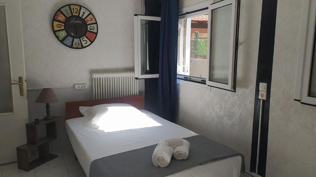 a bedroom with a bed and a clock on the wall at Enjoy Hospitallity at Fully Equipped apartment with Free parking- Near the Ancient Olympia in Pýrgos