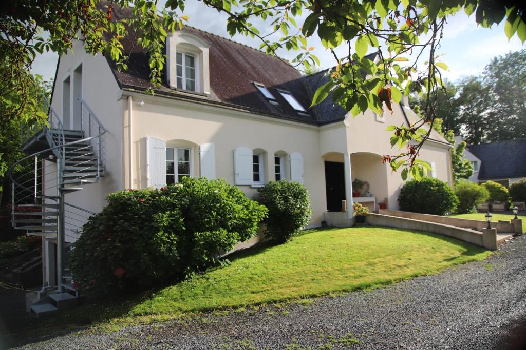 une maison blanche avec une cour verdoyante dans l'établissement Une pause à la campagne Classé 2 étoiles, à Saint-Urbain