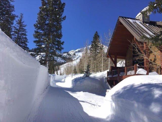 a snow covered road next to a building with a house at Twin Peaks Lodge in Brighton