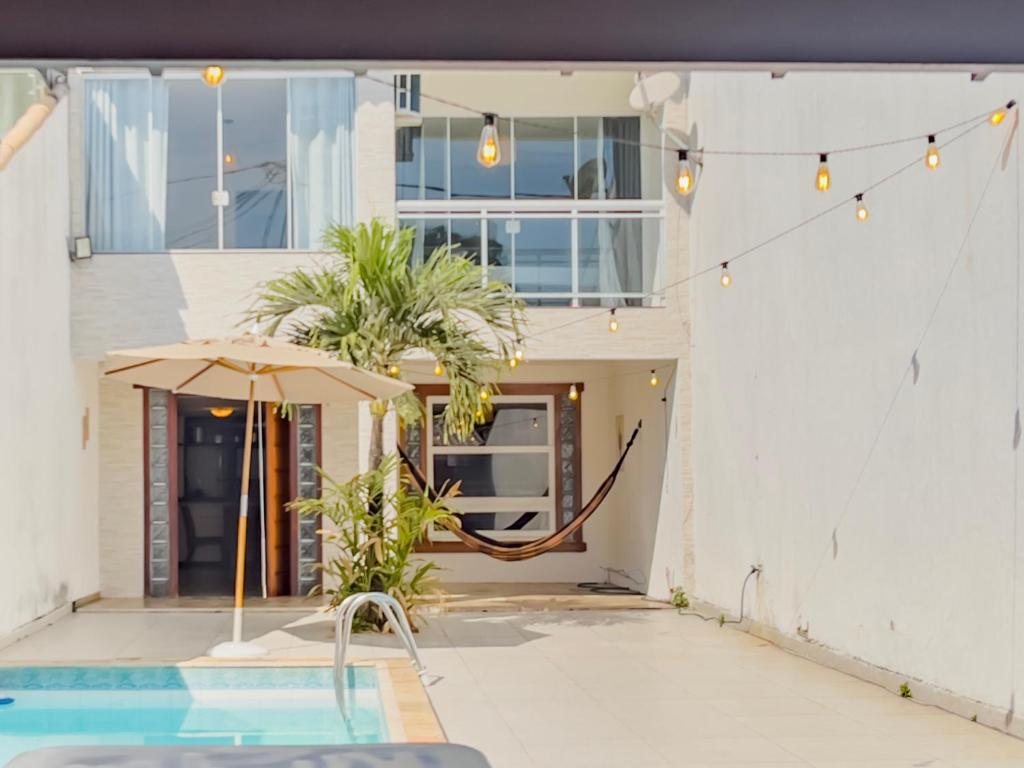 une maison avec un hamac et une piscine dans l'établissement Cabo Frio 3 Suítes, Piscina, 4 Vagas, Praia 8min, à Cabo Frio