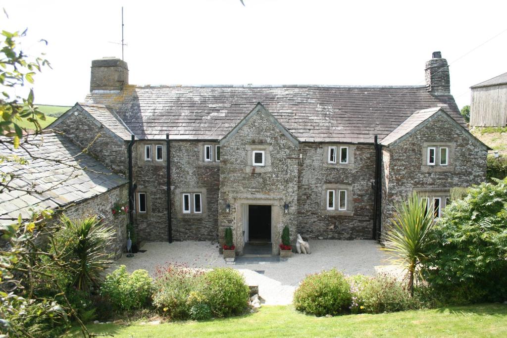 an old stone house with a large courtyard at Reddivallen Farmhouse in Boscastle