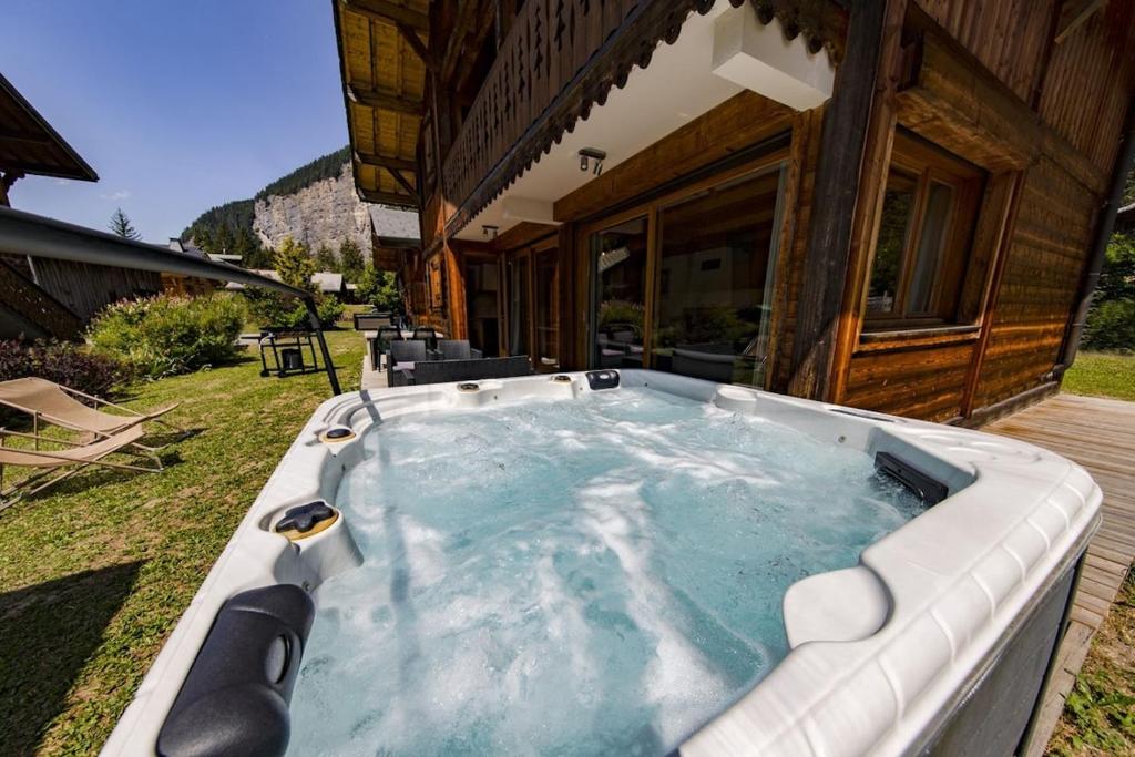 a hot tub sitting outside of a house at Hauts forts Prodains Avoriaz - Mountain Voyages in Morzine