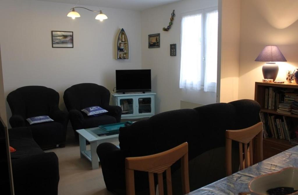 - un salon avec des chaises, une table et une télévision dans l'établissement Maison oleronaise, à Saint-Georges-dʼOléron