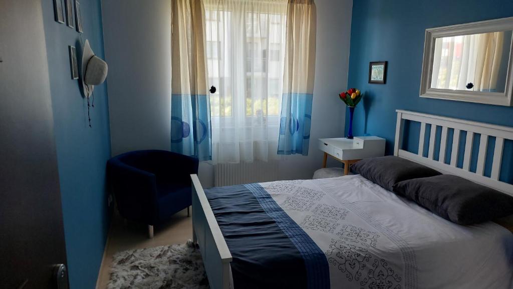 a bedroom with blue walls and a bed and a window at Nocleg u Kasi nad Morzem Trójmiasto in Kowale