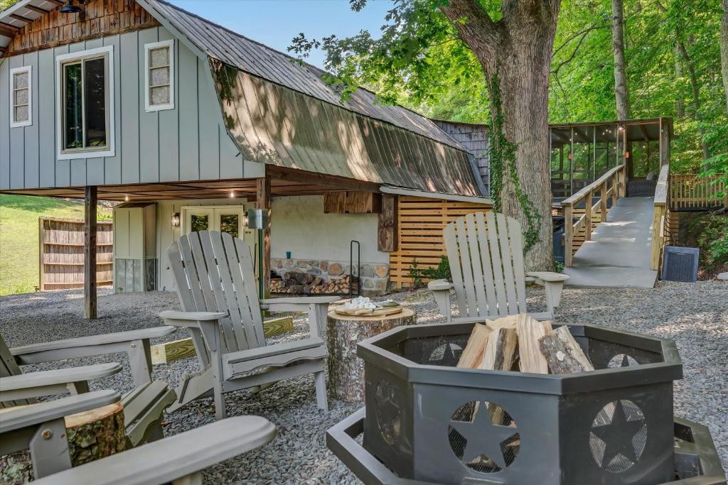 a cabin with chairs and a fire pit in front of it at Rustic Barn Retreat in Knoxville