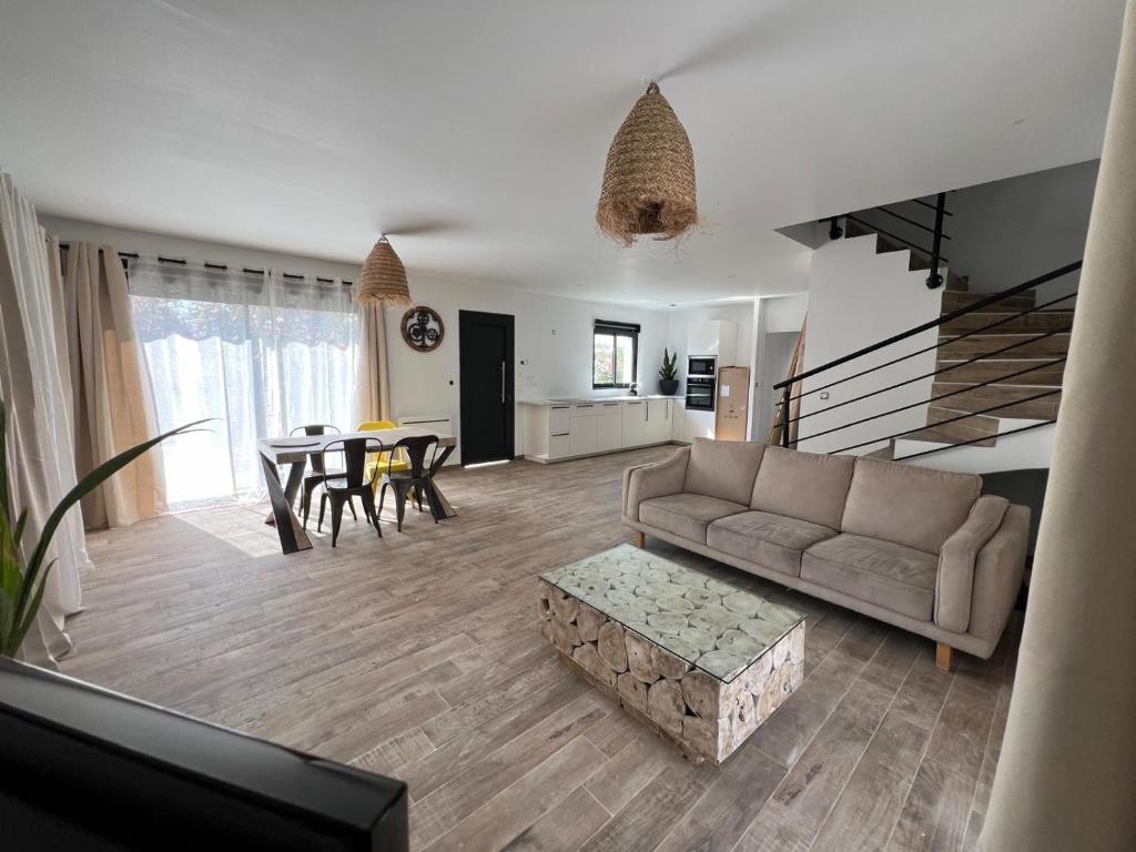 a living room with a couch and a table at Maison neuve 4 chambre avec jacuzzi in Les-Pennes-Mirabeau