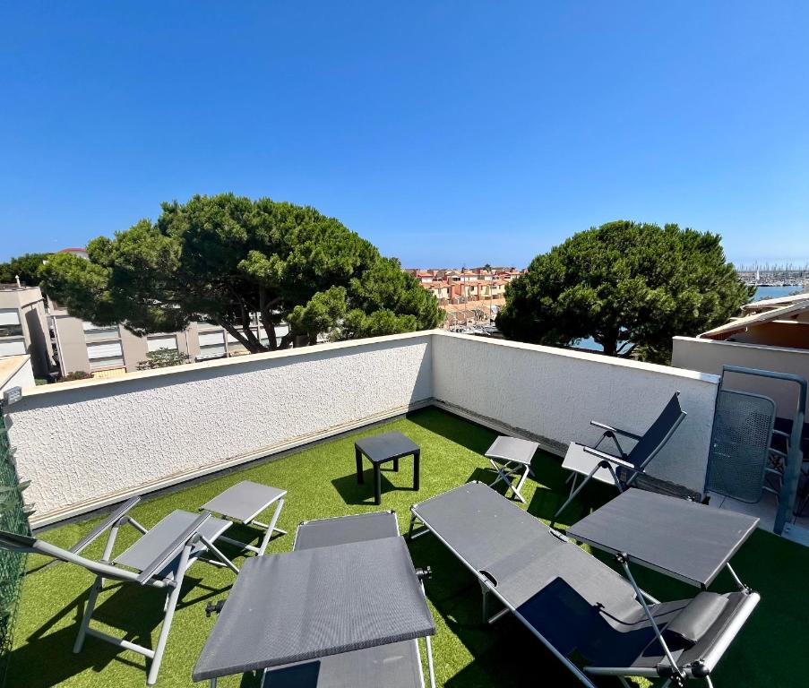 un patio avec des chaises et des tables sur un toit dans l'établissement L'appart B42, à Gruissan