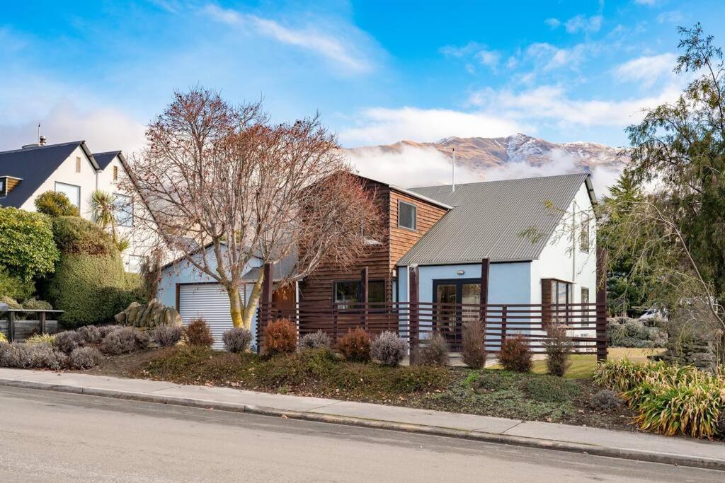 a house on a street with mountains in the background at Stonehaven in Wanaka