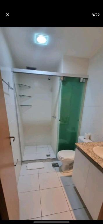 a bathroom with a toilet and a green door at Flat Hotel Saint Moritz ap 2008 in Brasilia