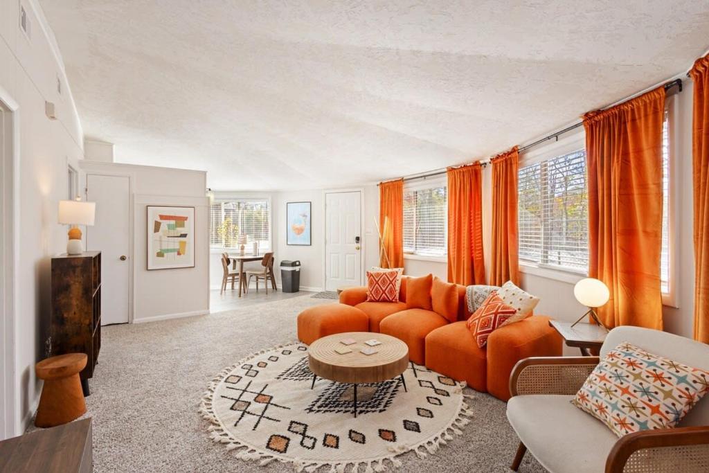 a living room with an orange couch and a table at Groovy Getaway with Fenced Yard in Augusta