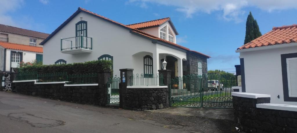 a white house with a black fence at Casas do Baleeiro - Vivenda do Terras in São Roque do Pico