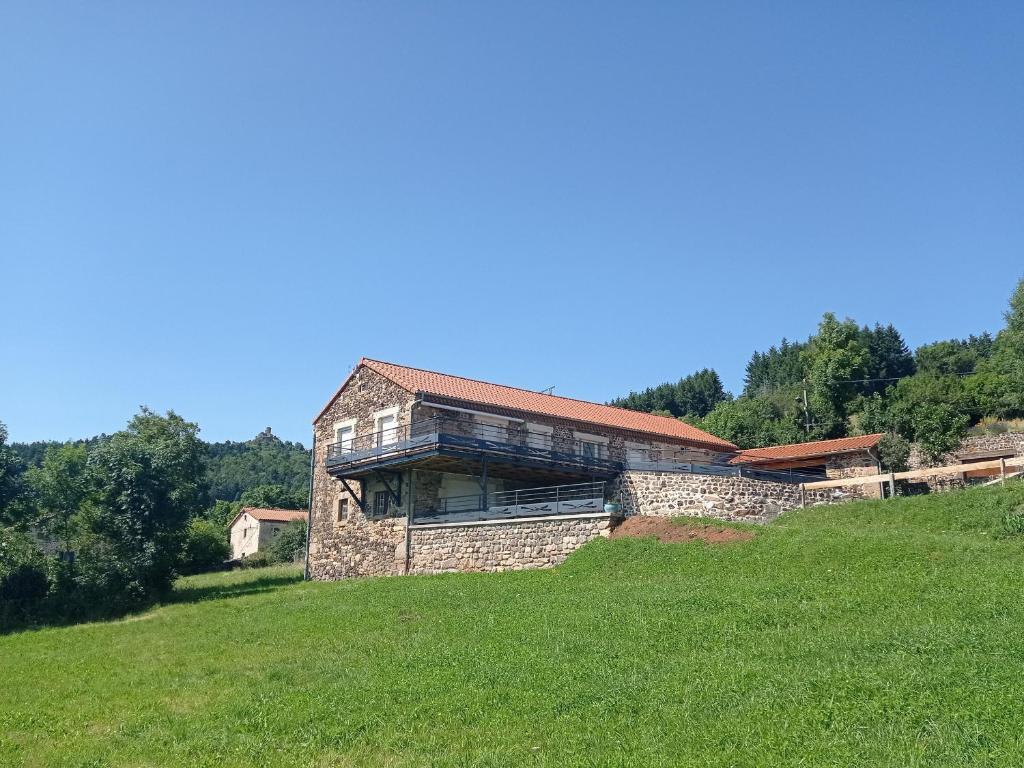 une maison sur une colline dans un champ dans l'établissement Gîte authentique et confortable avec vaste terrain et vue imprenable à Saint-Privat-d'Allier - FR-1-582-478, à Saint-Privat-dʼAllier