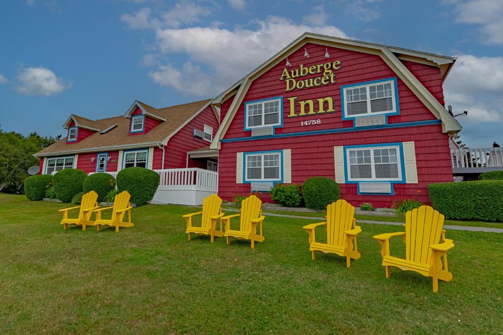 a group of yellow chairs in front of a building at Auberge Doucet Inn in Chéticamp