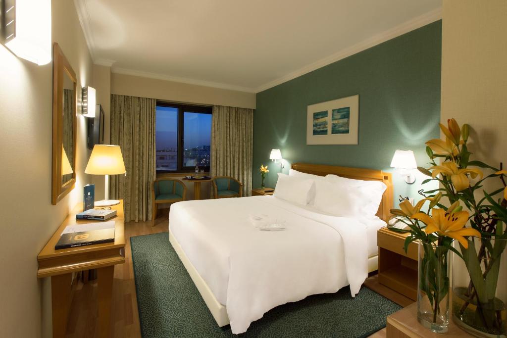um quarto de hotel com uma grande cama branca e uma janela em SANA Metropolitan Hotel em Lisboa