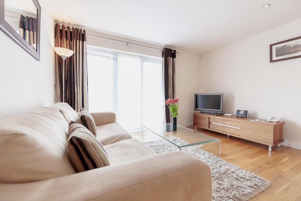 a living room with a couch and a tv at Roomspace Serviced Apartments - Marquis Court in Epsom