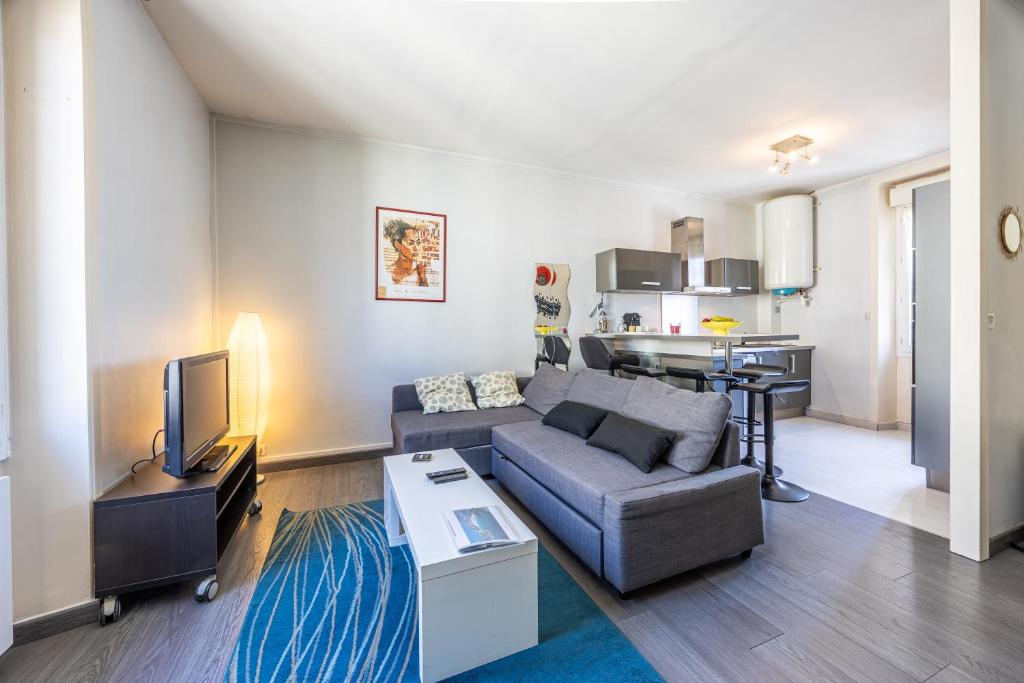 un salon avec un canapé et une télévision dans l'établissement Duplex hypercentre, à Dinard
