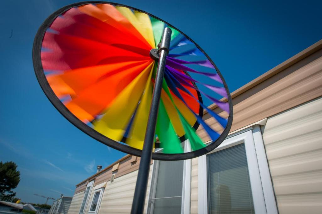 a rainbow colored umbrella hanging from the side of a building at Park Merlo in Bredene