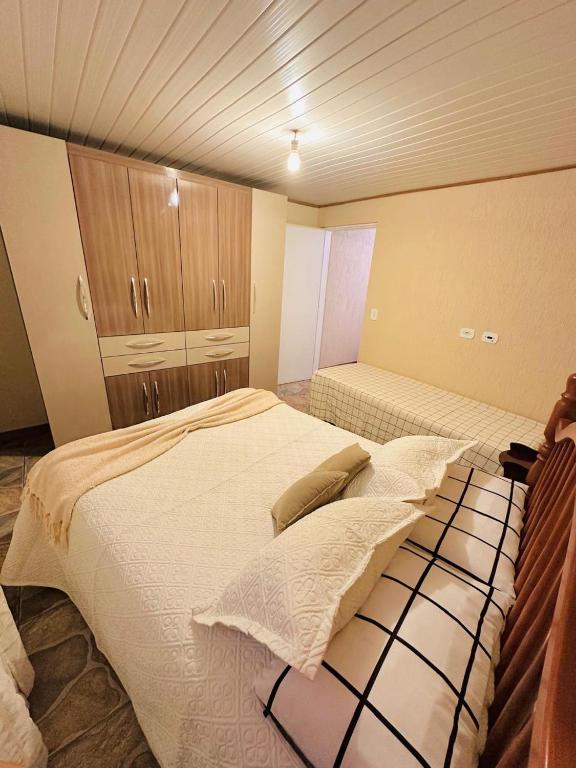 a bedroom with two beds and cabinets in it at Casa para temporada in Campos do Jordão
