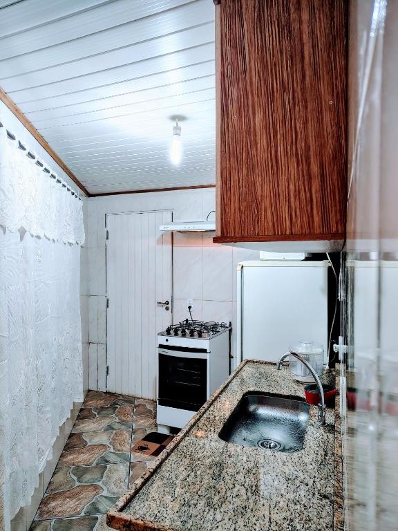 a kitchen with a sink and a stove at Casa para temporada in Campos do Jordão