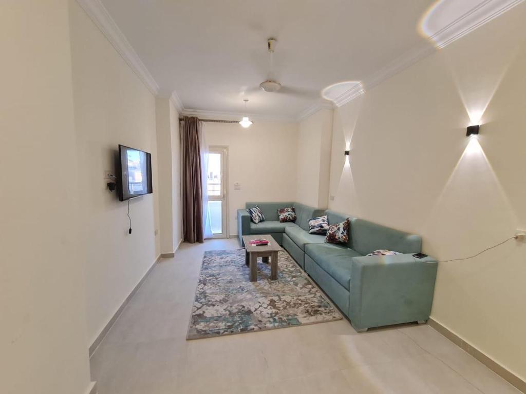 a living room with a green couch and a tv at Star house apartments in Hurghada