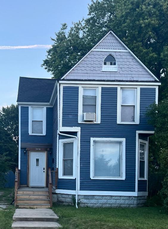 a blue house with a porch and a door at The Water Street House in Port Huron