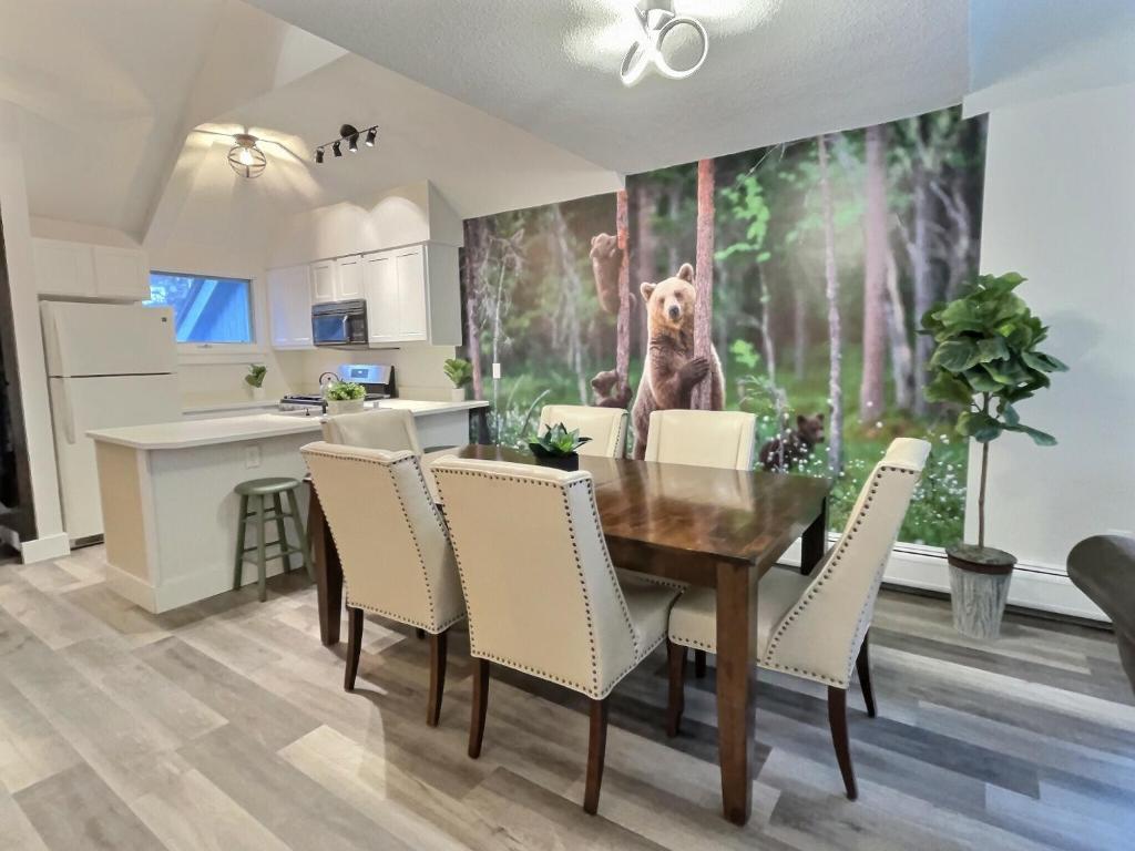 una cucina con un tavolo da pranzo con un dipinto di un orso sul muro di FirBear- AC, Pool, Hot Tub, Sauna, Tennis, Gym a Killington
