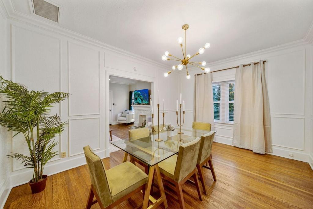 a dining room with a glass table and chairs at Walk To Cherry Street,pets, Hot Tub By Hvnlyhomes in Tulsa