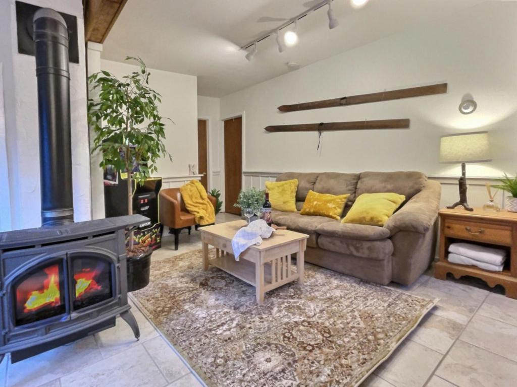 a living room with a couch and a fireplace at HappyCub- AC, Hot Tub, Fire Pit, Game Room! in Killington