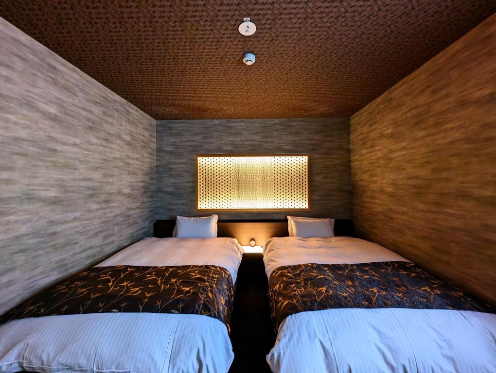 Postel nebo postele na pokoji v ubytování ひがし茶屋街らしく金沢 Hotel Rashiku kanazawa