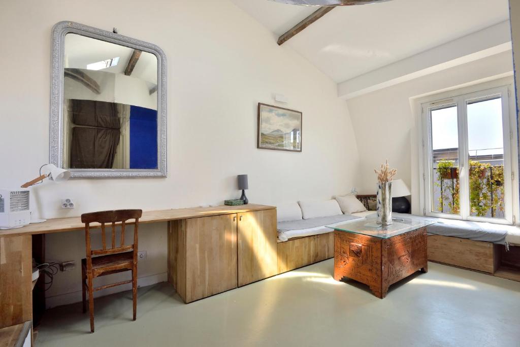 Cette chambre comprend une coiffeuse avec un miroir et une table. dans l'établissement Stylish attic conversion, à Paris