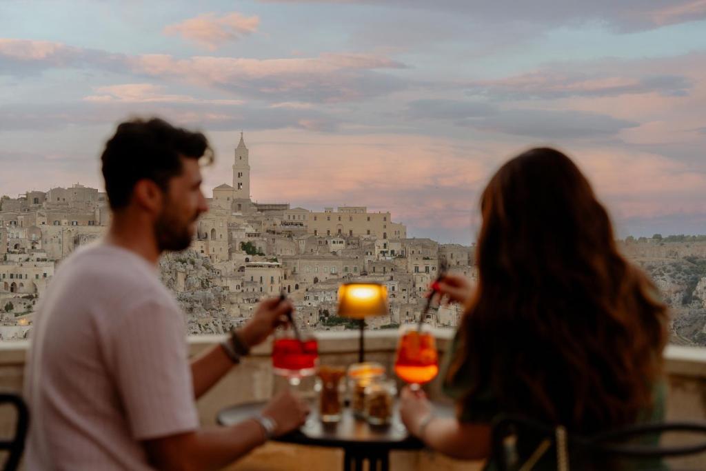 a group of people sitting at a table with a view of the city at Il Belvedere in Matera