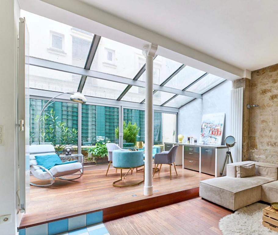 un salon avec un grand plafond en verre dans l'établissement Villa Lepic, Luxury flat in Montmartre with private terrasse-Appartement entier, à Paris