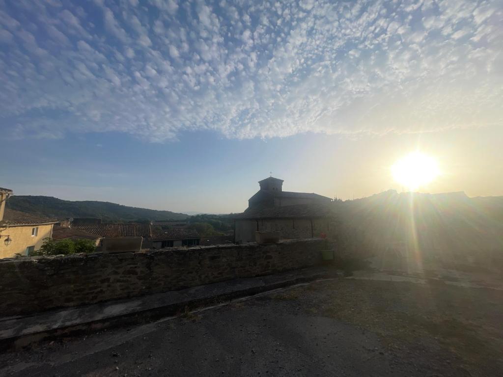 a view of the sun setting over a stone wall at La P’tite Maison de David in Saint-Hilaire