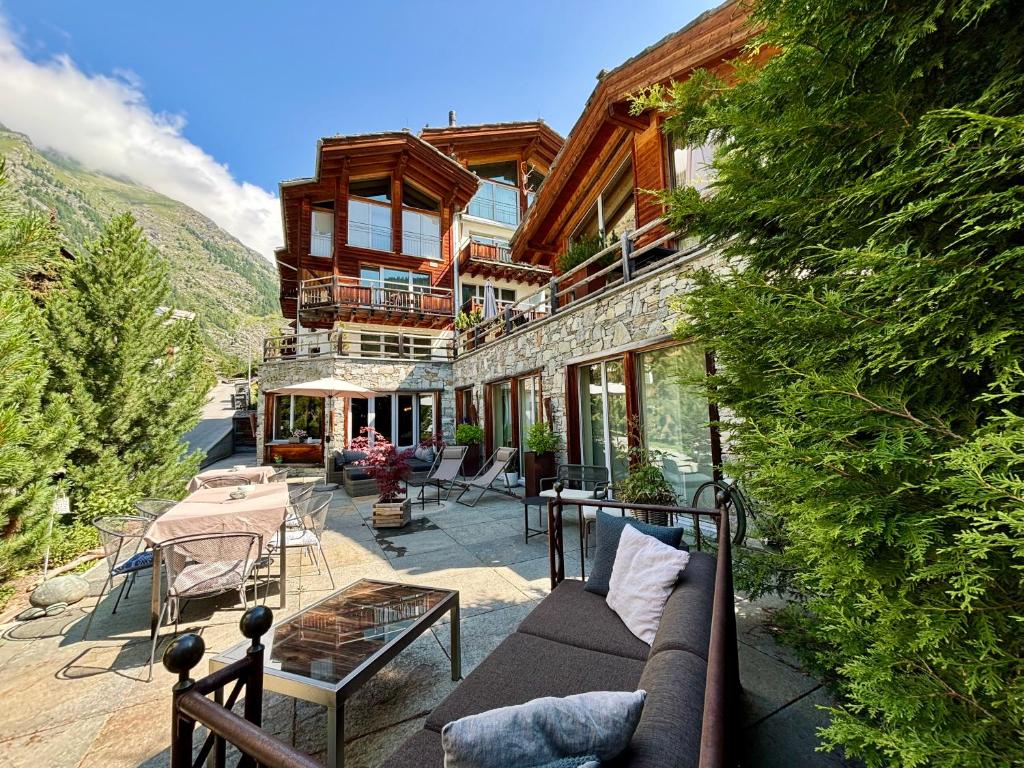 a house on a hill with a couch and chairs at Alpenlodge in Zermatt