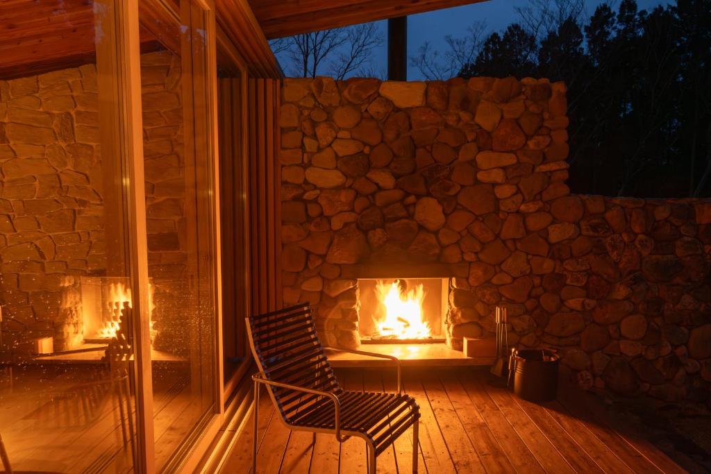 a chair sitting on a porch with a fireplace at 那須 無垢の音 in Nasu