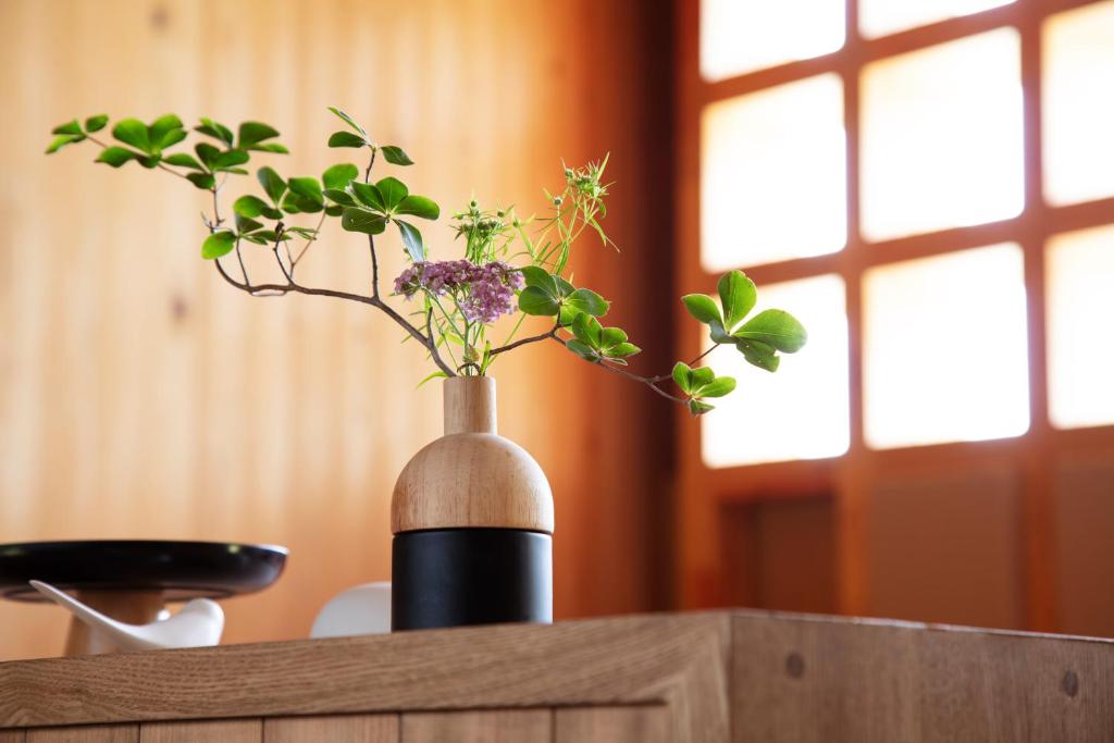 a vase with flowers in it on a table at 那須 無垢の音 in Nasu