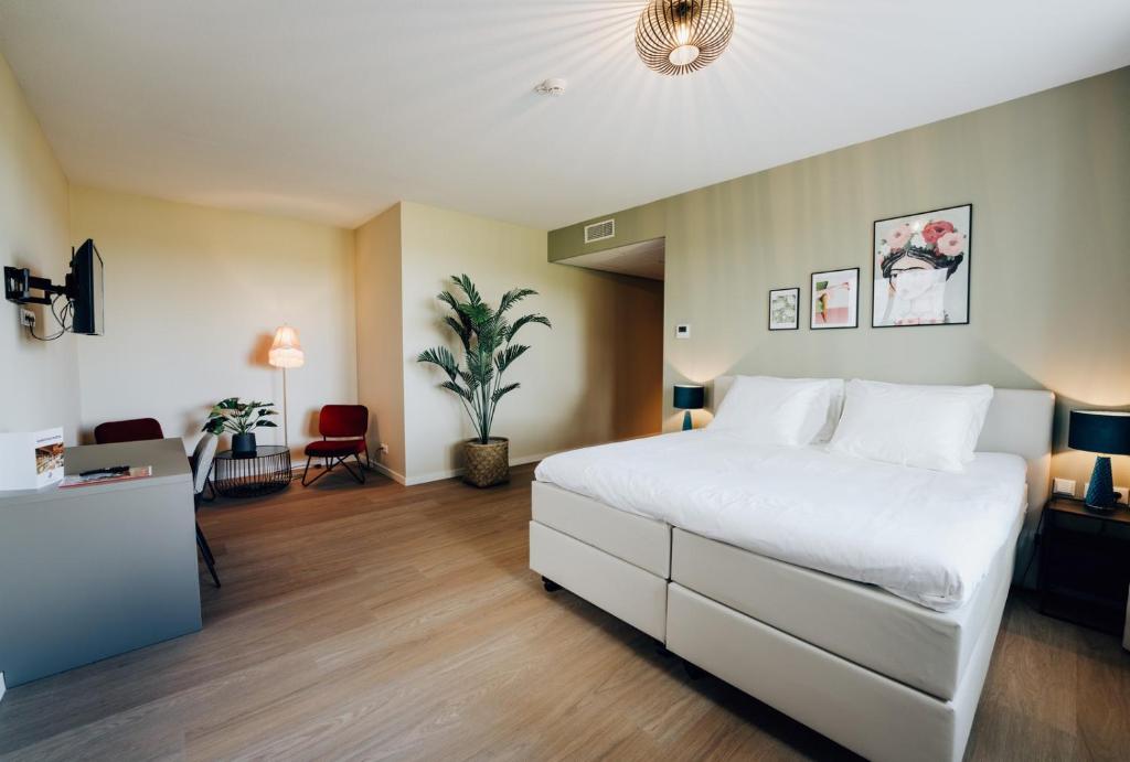 een slaapkamer met een groot wit bed in een kamer bij Boutique Hotel het Witte Veen in Witteveen