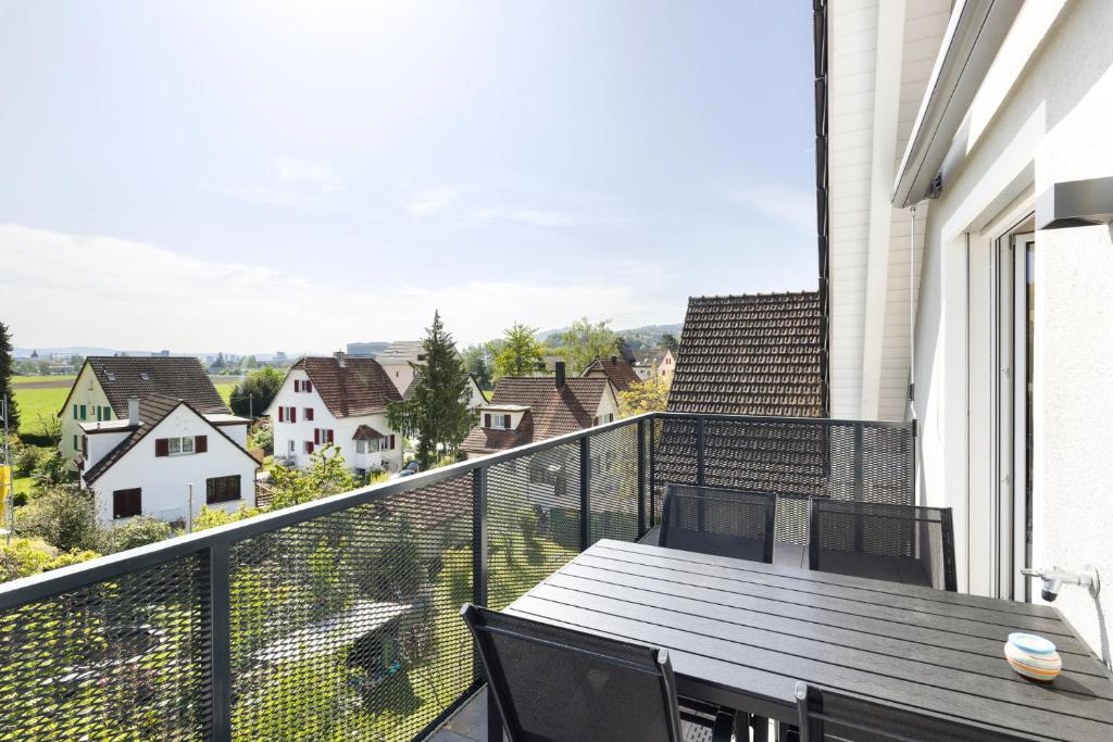 a balcony with a table and chairs and a view at STAYY Flagship Limmattal - contactless check-in in Schlieren
